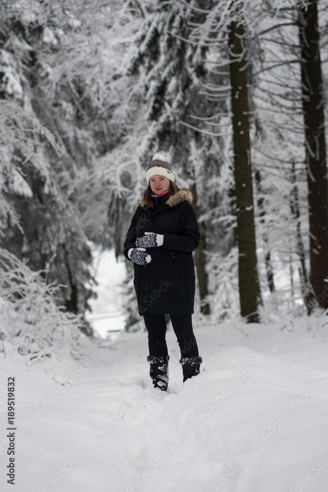 Pregnant woman a walk in winter landscape, beautiful snow-covered countryside. woman wearing black coat and winter hat.