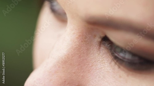 Close up shot of a lovely model's face wearing amazing make up outdoor. Her beautiful hairs are swinging on the wind. photo