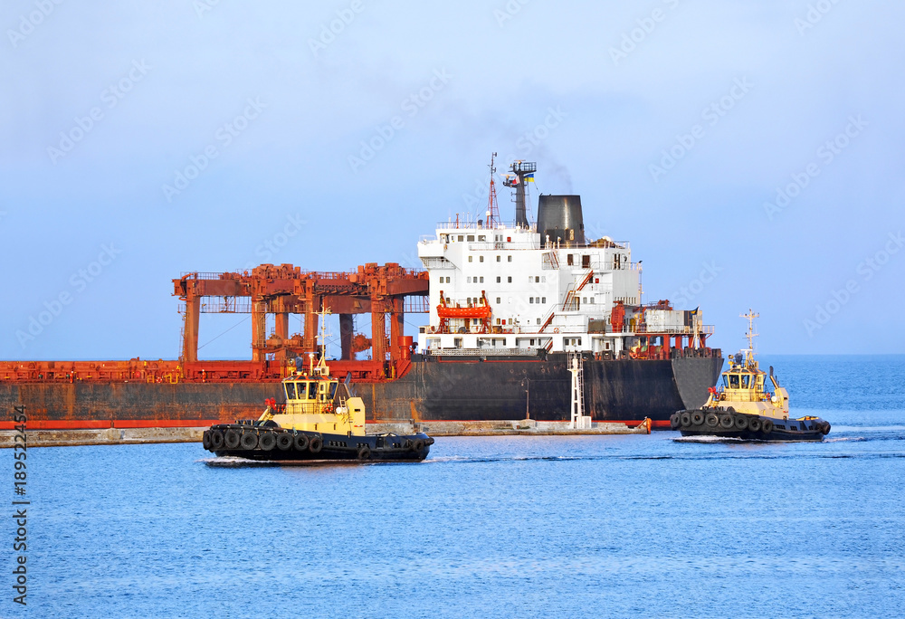 Tugboat assisting bulk cargo ship Tugboat assisting bulk cargo ship