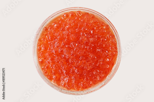 Glass bowl with red salmon caviar on white background. View from above. Popular souvenir from Russia.