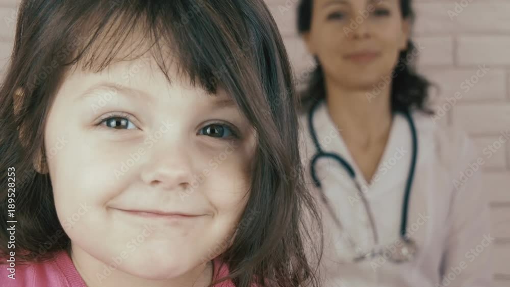 The child has a pediatrician. Little girl on the background of the doctor. The child has a pediatrician. Little girl on the background of the doctor.