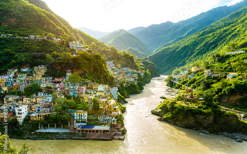Confluence of two rivers Alaknanda and Bhagirathi give rise to the holy river of Ganga / Ganges at one of the five Prayags called Dev Prayag. Lush greenery in monsoons on the mountains. sunrise. India photo