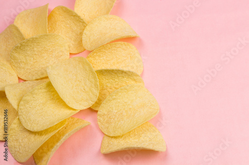 Potato chips on pastel pink background in minimalism style.