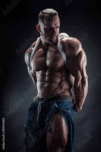 portrait of strong Athletic Fitness man showing big muscles