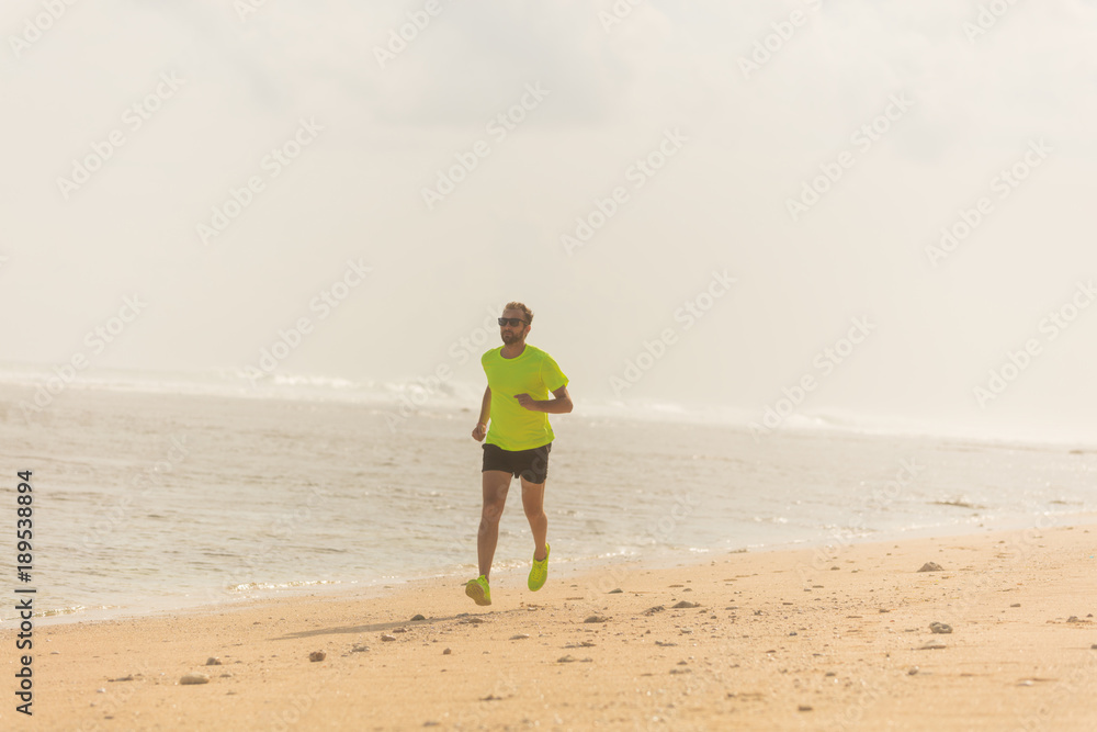 Jogging on a tropical sandy beach near sea / ocean.