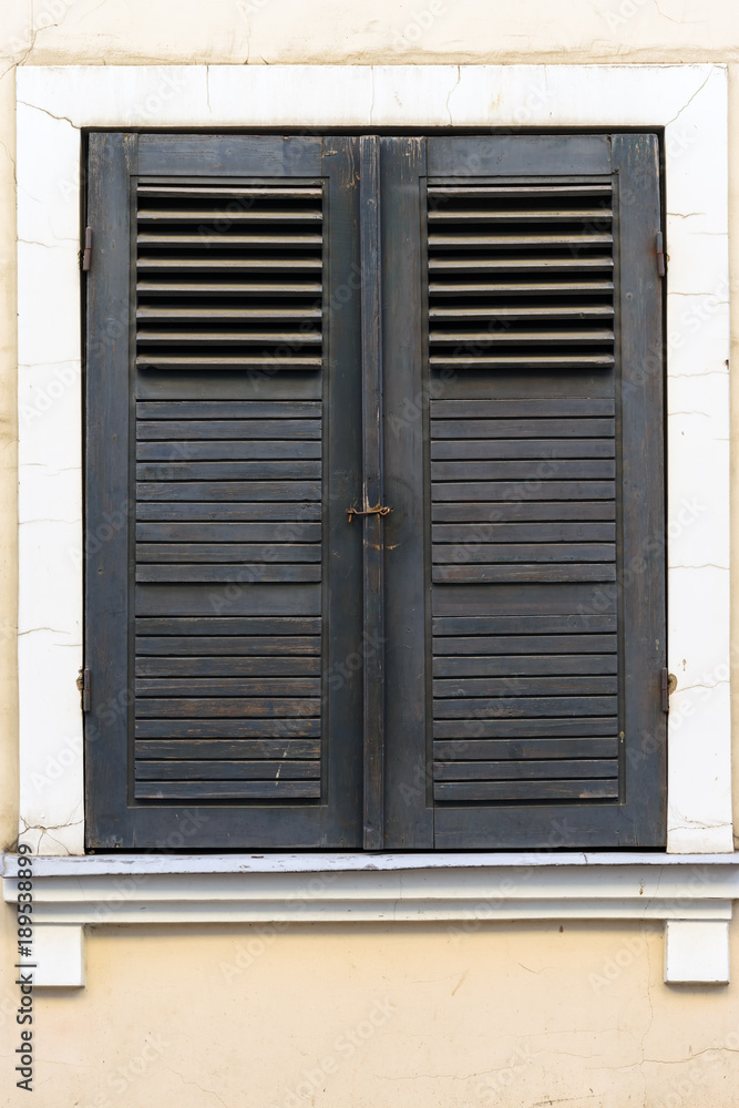 old windows with brown wooden shutter, classic facade