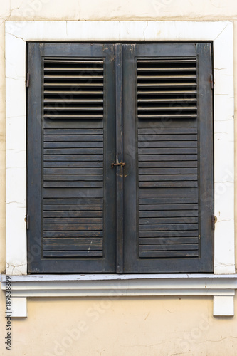 old windows with brown wooden shutter  classic facade