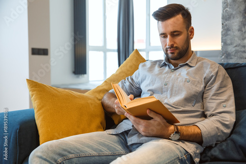 Εκτύπωση καμβά Bachelor man daily routine in the living room single lifestyle concept reading b