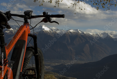 ebike, e-bike, electric bicycle, high mountain, leaning against tree, detail of handlebars, wheel, saddle, display, alps landscape, snow covered tops, autumn, winter, Antrona Valley, Piedmont, Italy