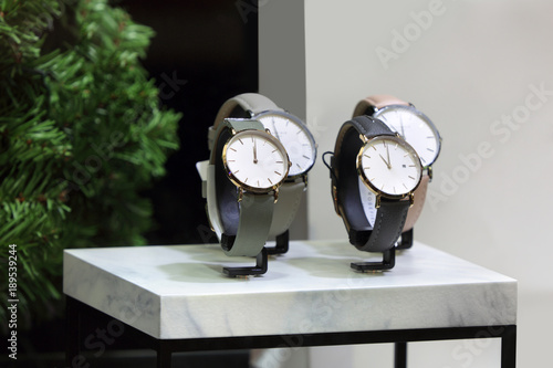 Piękne męskie zegarki z białą tarczą na marmurowej podstawce.