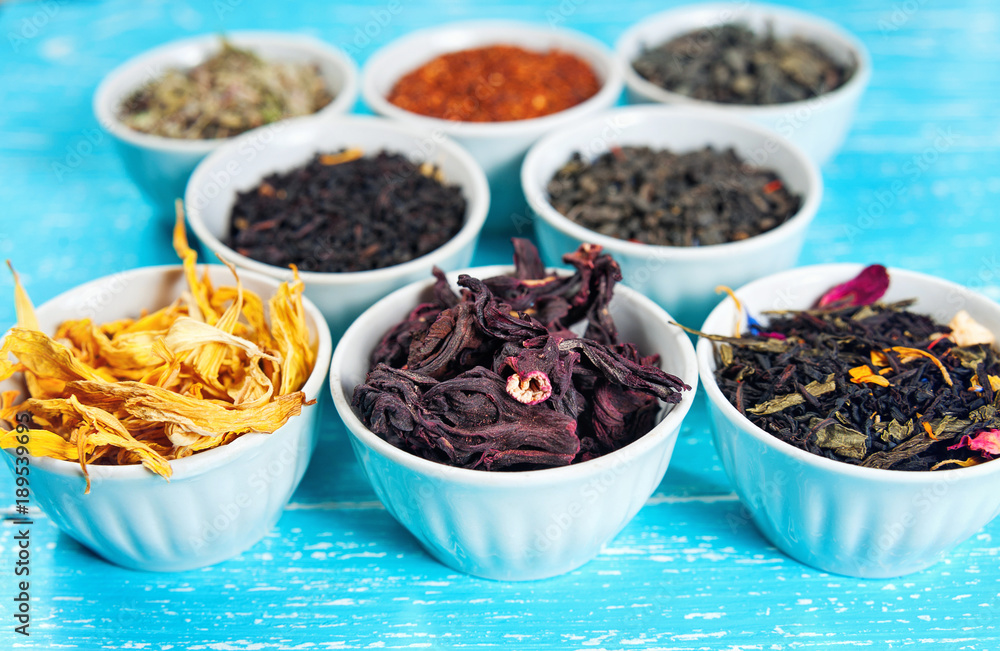 herbs and teas in bowls to make tea on blue table background cl herbs and teas in bowls to make tea on blue table background cl