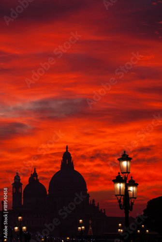 Venice red blood sky sunset with Salute Basilica domes and lamps