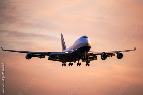 Large passenger airplane landing at international airport at sunset. photo