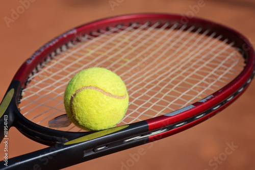 tennis racket and balls on the clay court