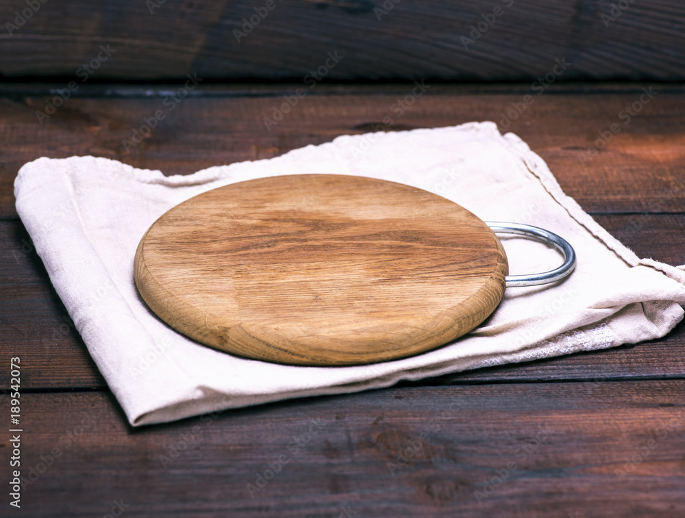 empty round wooden board on a gray napkin