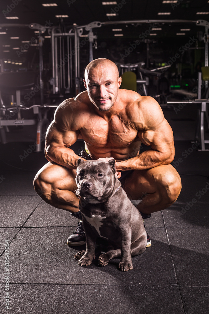 Naklejka premium bodybuilder posing with dog