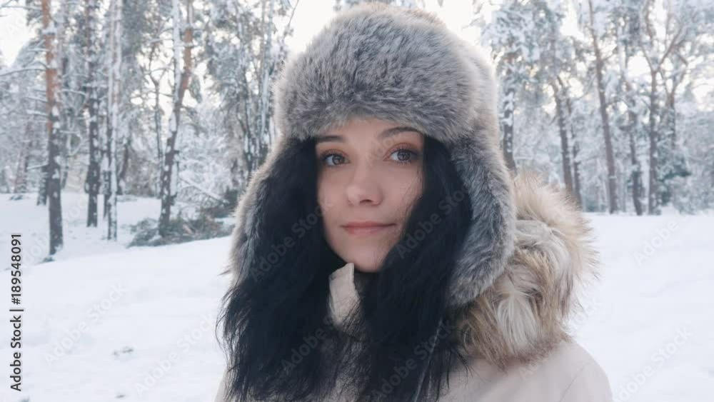 Close up portrait of beautiful young in hat woman at winter snowy forest Close up portrait of beautiful young in hat woman at winter snowy forest