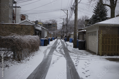 Snow covered alleyway with tire tracks © Richard