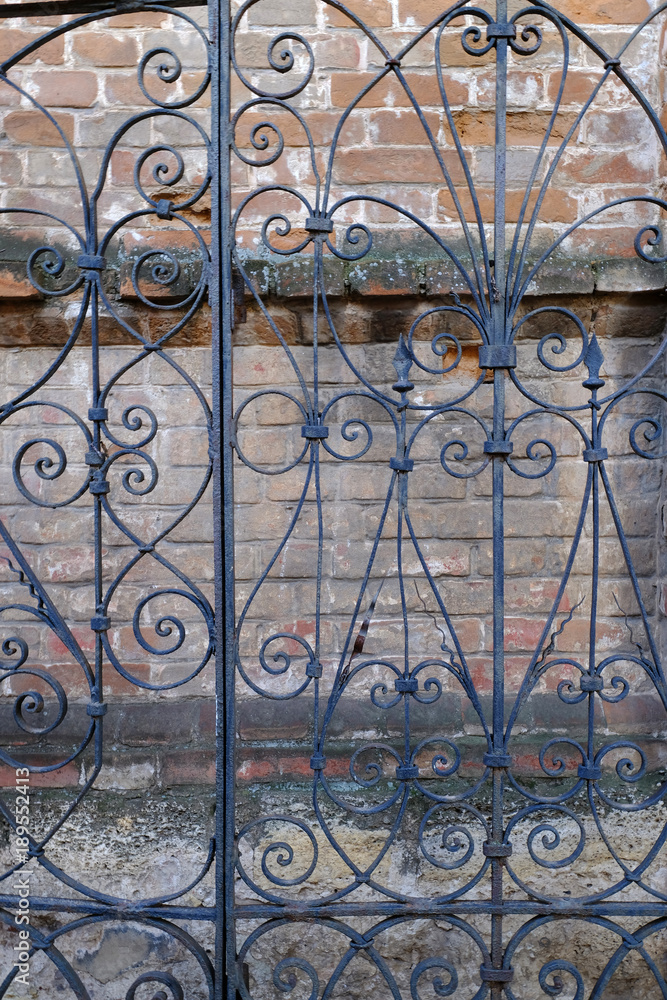 Ancient wrought-iron gates near the old wall of the house.