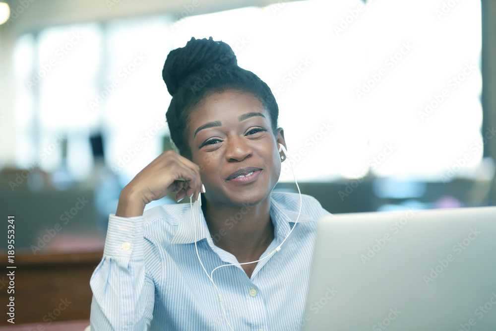 Happy black girl sitting at laptop