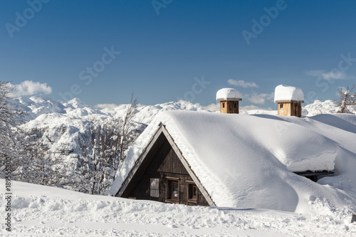 Winter landscape with small wooden house
