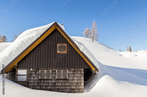 Winter landscape with small wooden house