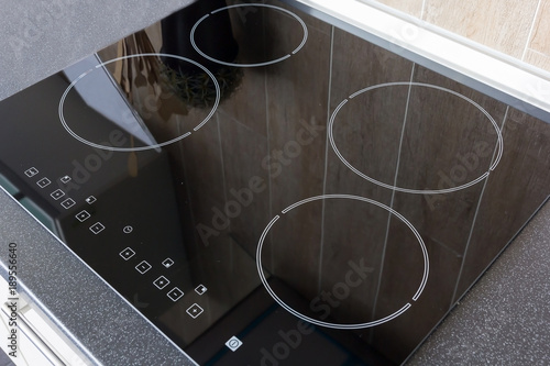 Close up view of an electrical kitchen induction ceramic hob with kitchen furniture