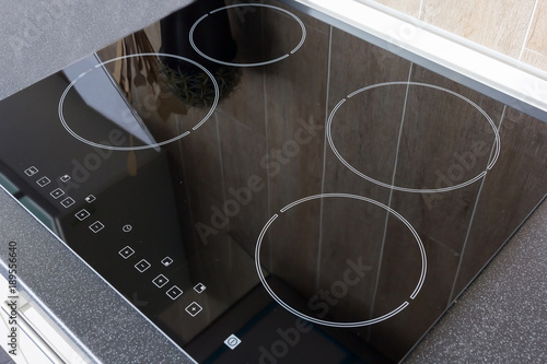 Vászonkép Close up view of an electrical kitchen induction ceramic hob with kitchen furnit
