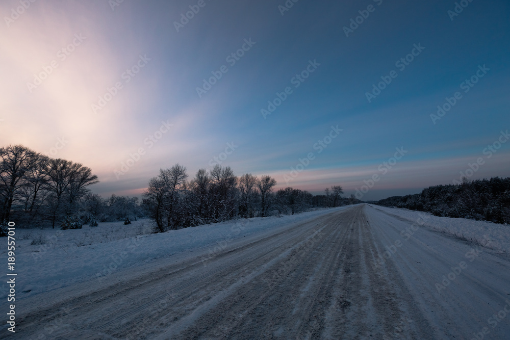 Winter road through snowy fields and forests Winter road through snowy fields and forests