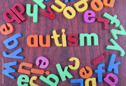 Autism text with scattered alphabets on woden table.