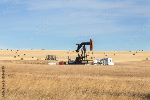 A single oil pump jack in the farm field. Oil industry equipment. Calgary, Alberta, Canada.