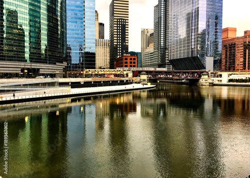 Colorful reflection of cityscape on a freezing Chicago River in winter during rush hour.