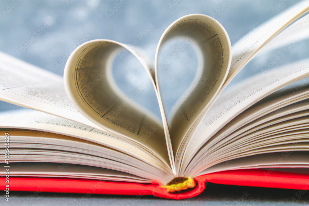 The pages of the book in the red cover are made in the form of a heart. The concept of Valentine's Day. The pages of the book in the red cover are made in the form of a heart. The concept of Valentine's Day.