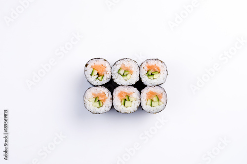 Classic mini sushi rolls with salmon and cucumber top view.