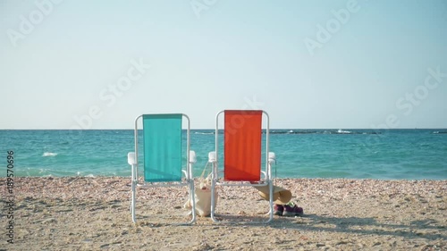 Two beach chairs and clothes on the shore of the Mediterranean Sea in Israel.