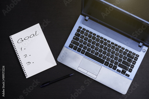 Notebook and computer on wood background. © Kritmongkholrat