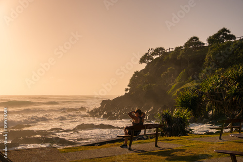 Gold Coast, Queensland/Australia - 18 January 2018: A woman enjoys sunrise looking across Point Danger on the Southern Gold Coast, Australia.