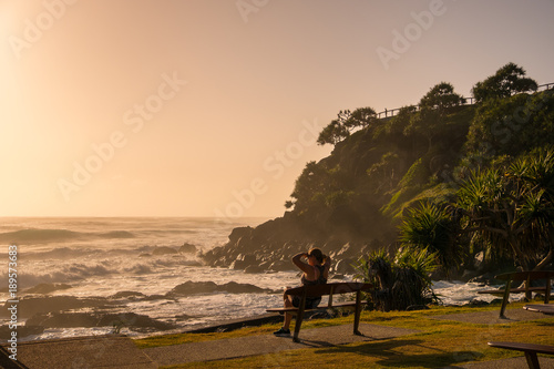 Gold Coast, Queensland/Australia - 18 January 2018: A woman enjoys sunrise looking across Point Danger on the Southern Gold Coast, Australia. photo