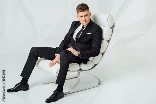 Photography young business man in modern suit sitting on chair