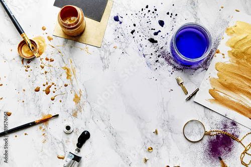 Paints and color splashes on artist's workplace. White background.