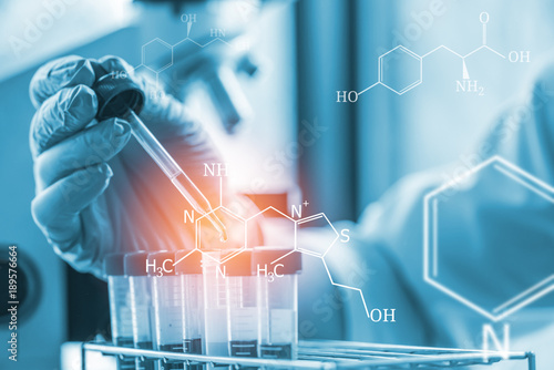 scientist or doctor dropping a blood into blood test tube in rack , science research  concept