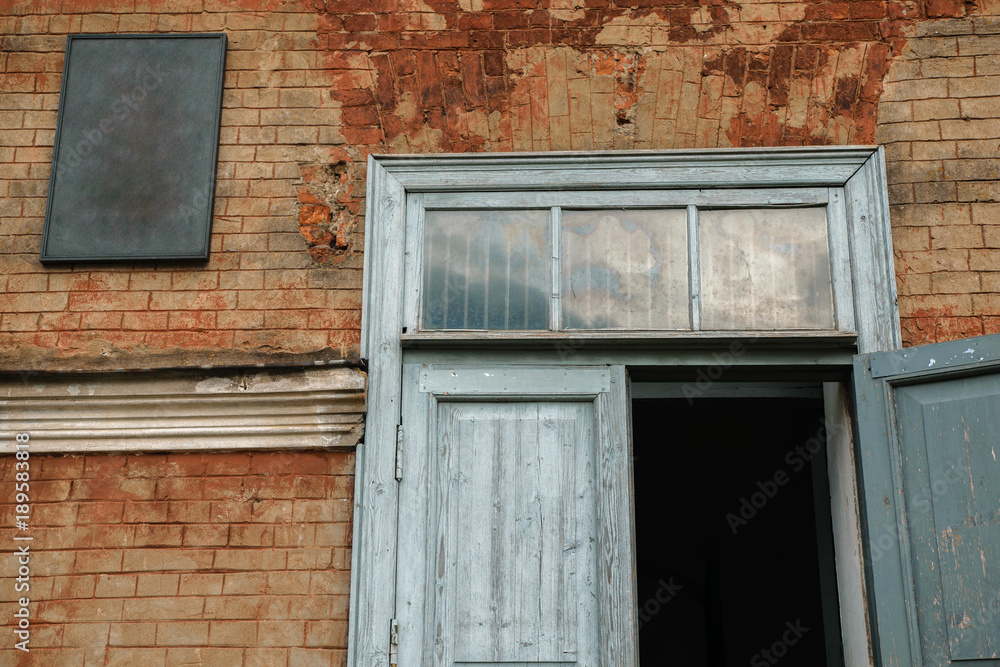 Fototapeta premium Old blue wooden door and red brick wall