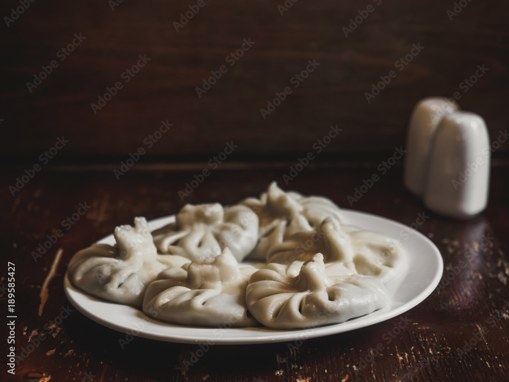 close up view of traditional georgian khinkali on plate on wooden tabletop close up view of traditional georgian khinkali on plate on wooden tabletop