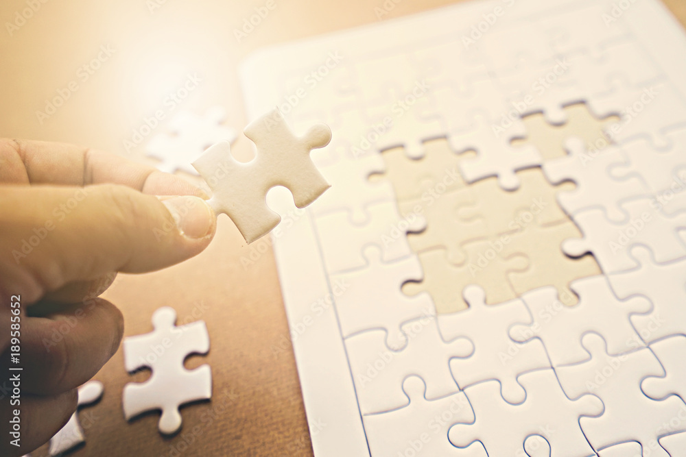 Fototapeta premium Hand holding a piece of jigsaw.