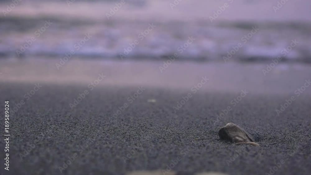 Shallow depth of field, sea waves splashing shore, ocean foam on sandy beach at night Shallow depth of field, sea waves splashing shore, ocean foam on sandy beach at night