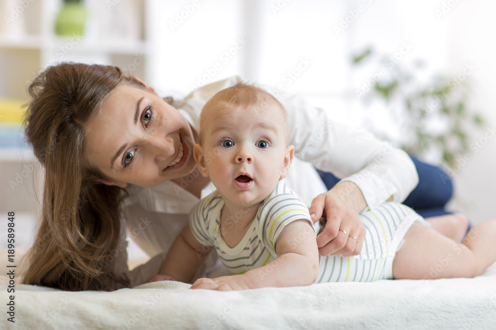 Mom and little son on bed. Mother embracing infant baby. Mom and little son on bed. Mother embracing infant baby.