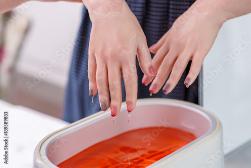 Fototapeta The use of paraffin in manicure.