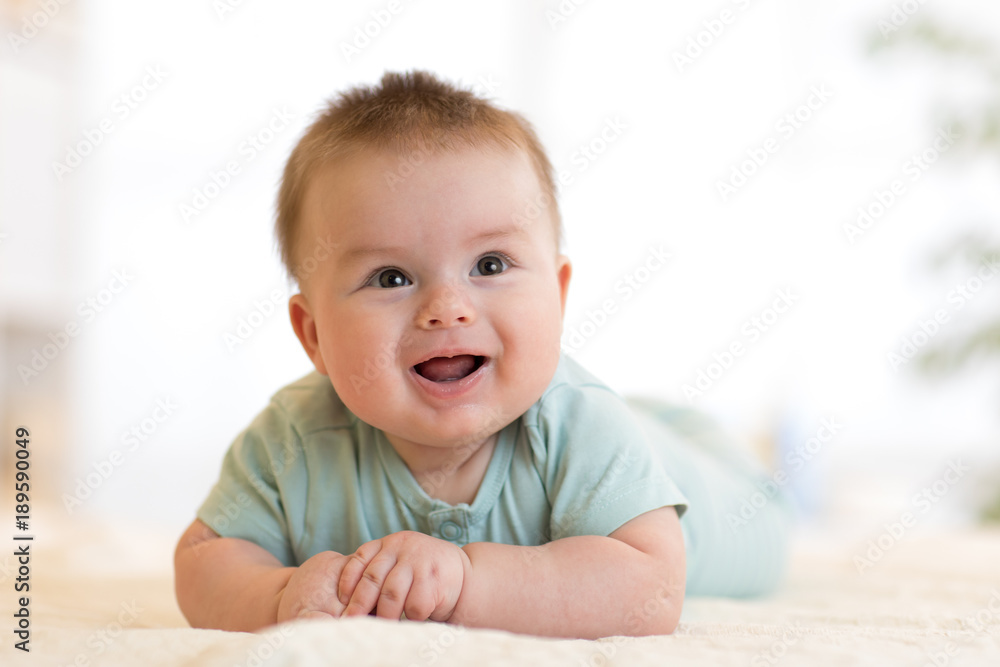 cute happy caucasian baby boy lies smiling on bed cute happy caucasian baby boy lies smiling on bed