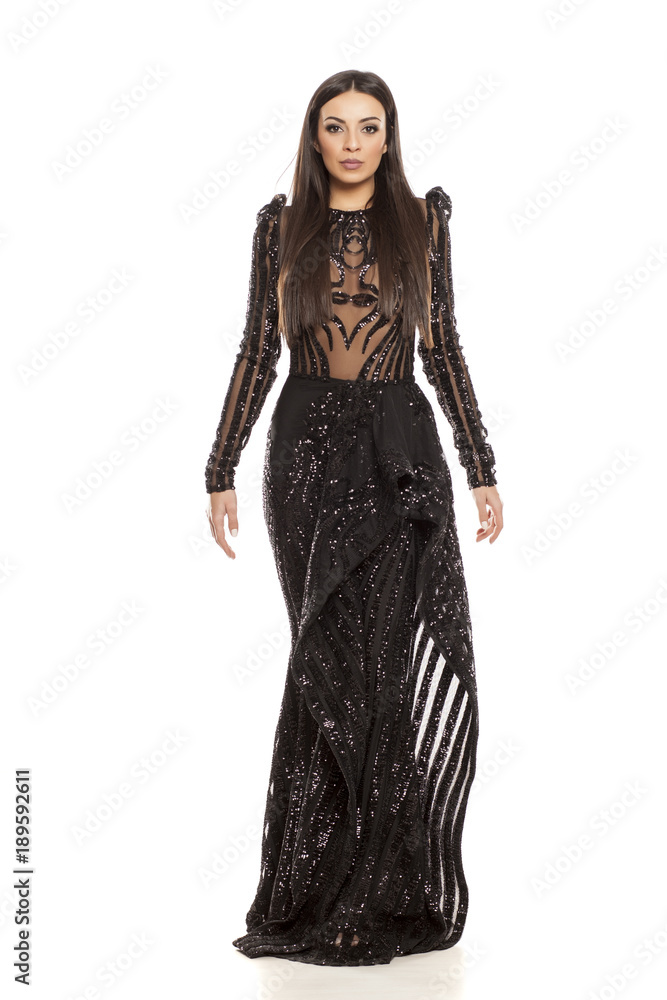 young beautiful woman in a black evening dress on a white background