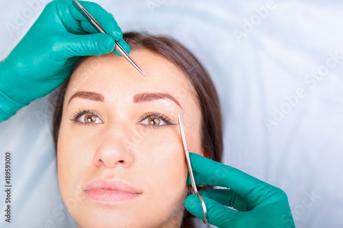 Cosmetic surgeon examining female client in clinik  before plastic surgery. Blepharoplasty